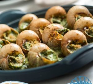 Prato de escargot gratinado servido em bandeja durante a Festa de Escargot de Taíba